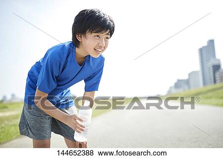 Stock Photo - Happy Japanese teenager enjoying himself outdoors. Fotosearch