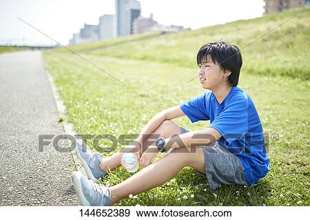 Stock Photo - Happy Japanese teenager enjoying himself outdoors. Fotosearch