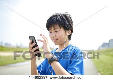 Happy Japanese teenager enjoying himself outdoors View Large Photo Image Stock Photo - Happy Japanese teenager enjoying himself outdoors. Fotosearch
