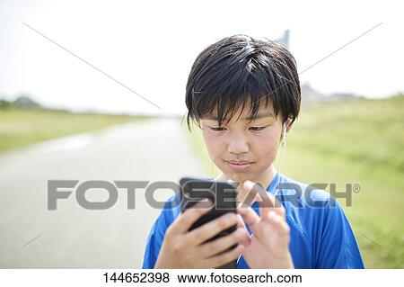 Stock Photo - Happy Japanese teenager enjoying himself outdoors. Fotosearch