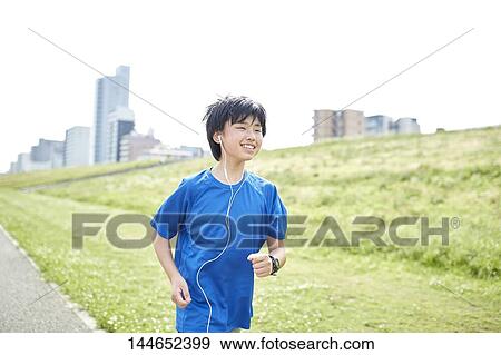 Stock Photo - Happy Japanese teenager enjoying himself outdoors. Fotosearch