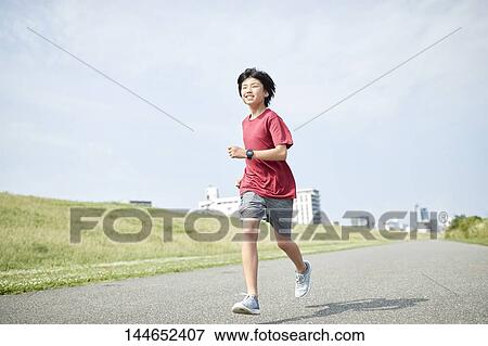Stock Photo - Happy Japanese teenager enjoying himself outdoors. Fotosearch