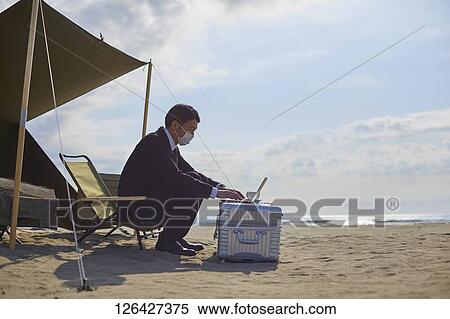 Japanese businessman working at the beach View Large Photo Image Stock Photography - Japanese businessman working at the beach. Fotosearch