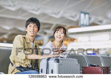 Stock Image - Japanese couple at the airport. Fotosearch