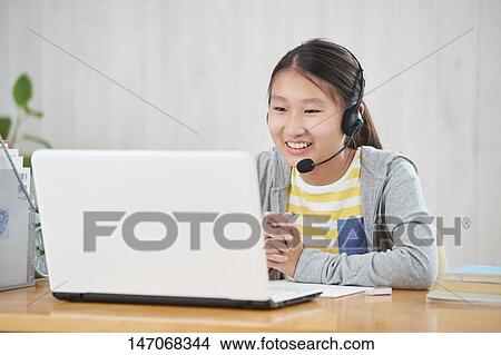 Picture - Japanese junior high schoolgirl studying remotely. Fotosearch