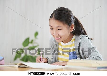 Stock Photo - Japanese junior high schoolgirl studying remotely. Fotosearch