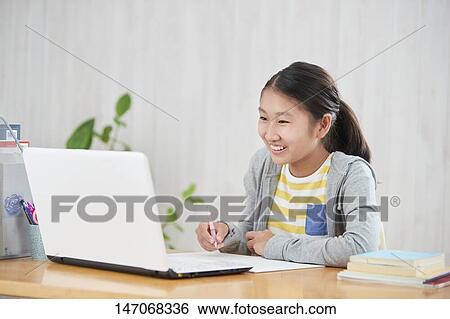 Stock Photograph - Japanese junior high schoolgirl studying remotely. Fotosearch