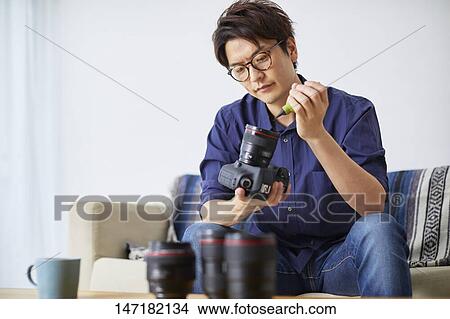 Japanese man cleaning camera at home View Large Photo Image Picture - Japanese man cleaning camera at home. Fotosearch