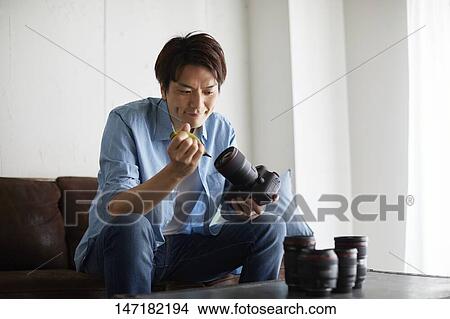 Japanese man cleaning camera at home View Large Photo Image Picture - Japanese man cleaning camera at home. Fotosearch