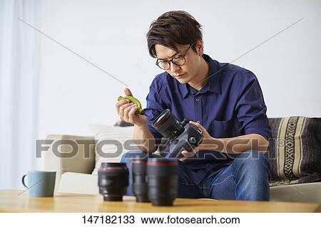 Japanese man cleaning camera at home View Large Photo Image Stock Image - Japanese man cleaning camera at home. Fotosearch