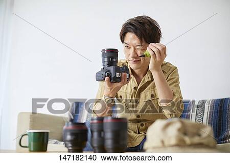 Japanese man cleaning camera at home View Large Photo Image Stock Image - Japanese man cleaning camera at home. Fotosearch