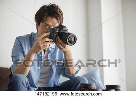 Japanese man cleaning camera at home View Large Photo Image Stock Photograph - Japanese man cleaning camera at home. Fotosearch