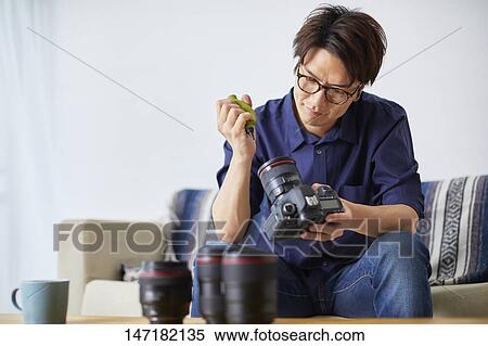 Japanese man cleaning camera at home View Large Photo Image Stock Photography - Japanese man cleaning camera at home. Fotosearch