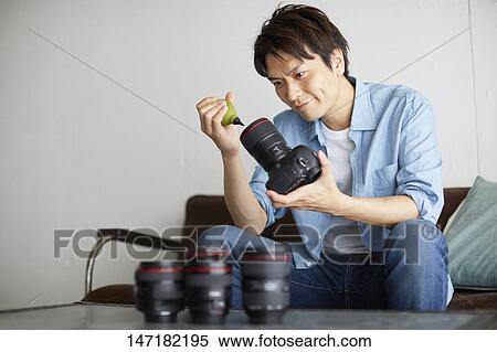Japanese man cleaning camera at home View Large Photo Image Stock Photography - Japanese man cleaning camera at home. Fotosearch