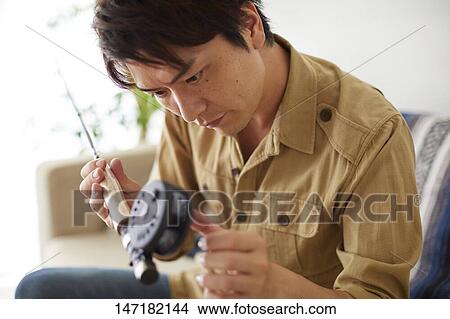 Japanese man cleaning fishing rod at home View Large Photo Image Picture - Japanese man cleaning fishing rod at home. Fotosearch