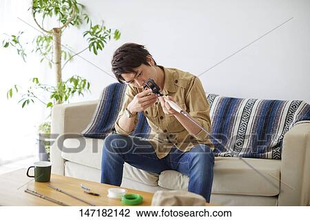 Japanese man cleaning fishing rod at home View Large Photo Image Stock Image - Japanese man cleaning fishing rod at home. Fotosearch