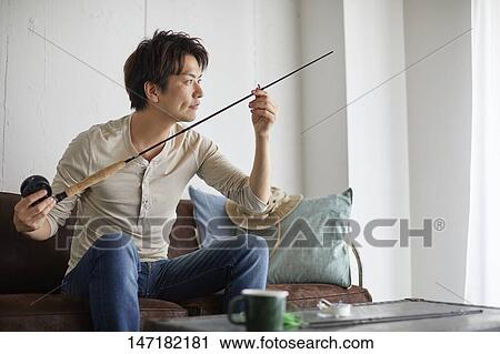 Japanese man cleaning fishing rod at home View Large Photo Image Stock Image - Japanese man cleaning fishing rod at home. Fotosearch