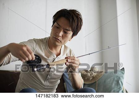 Japanese man cleaning fishing rod at home View Large Photo Image Stock Image - Japanese man cleaning fishing rod at home. Fotosearch