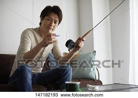 Japanese man cleaning fishing rod at home View Large Photo Image Stock Image - Japanese man cleaning fishing rod at home. Fotosearch