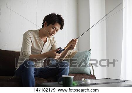 Japanese man cleaning fishing rod at home View Large Photo Image Stock Photo - Japanese man cleaning fishing rod at home. Fotosearch