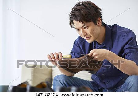 Japanese man cleaning shoes at home View Large Photo Image Picture - Japanese man cleaning shoes at home. Fotosearch