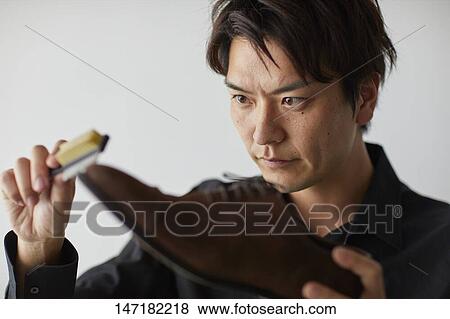 Japanese man cleaning shoes at home View Large Photo Image Stock Photo - Japanese man cleaning shoes at home. Fotosearch