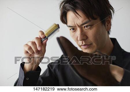 Japanese man cleaning shoes at home View Large Photo Image Stock Photo - Japanese man cleaning shoes at home. Fotosearch