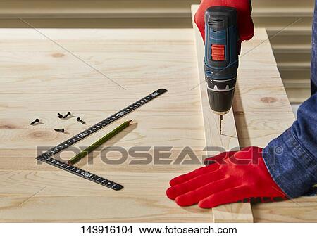Picture - Japanese man doing DIY. Fotosearch