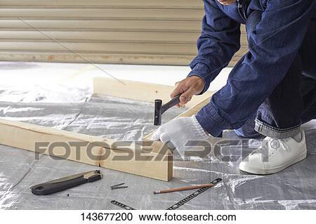 Stock Image - Japanese man doing DIY. Fotosearch