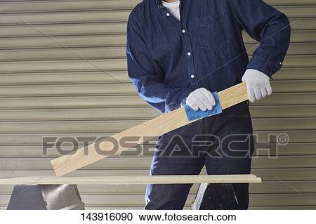 Stock Image - Japanese man doing DIY. Fotosearch