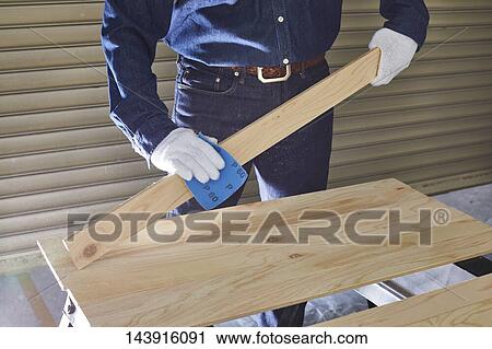 Stock Image - Japanese man doing DIY. Fotosearch