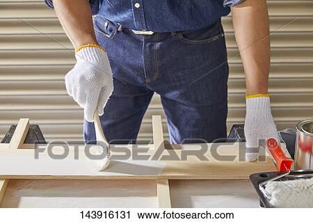 Stock Image - Japanese man doing DIY. Fotosearch