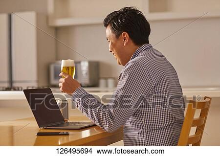 Japanese man drinking at home remote drinking View Large Photo Image Picture - Japanese man drinking at home remote drinking. Fotosearch