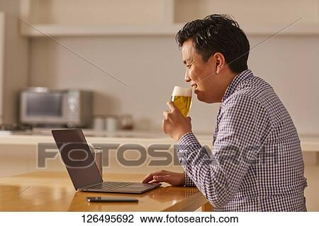 Japanese man drinking at home remote drinking View Large Photo Image Stock Image - Japanese man drinking at home remote drinking. Fotosearch