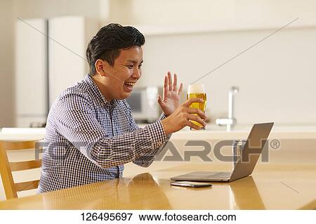 Japanese man drinking at home remote drinking View Large Photo Image Stock Photo - Japanese man drinking at home remote drinking. Fotosearch