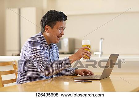 Japanese man drinking at home remote drinking View Large Photo Image Stock Photo - Japanese man drinking at home remote drinking. Fotosearch