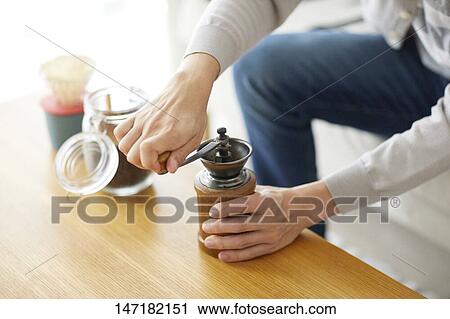 Stock Image - Japanese man making coffee at home. Fotosearch