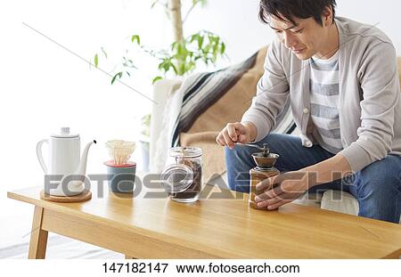 Stock Photo - Japanese man making coffee at home. Fotosearch