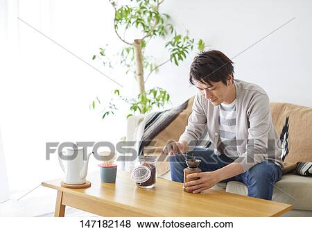 Japanese man making coffee at home View Large Photo Image Stock Photo - Japanese man making coffee at home. Fotosearch