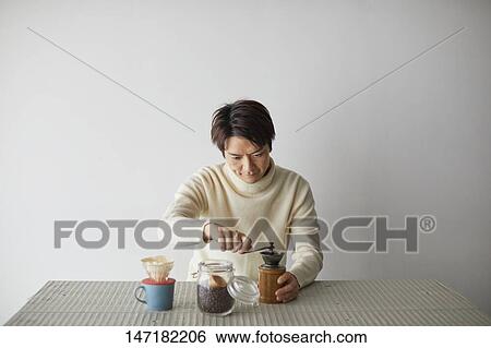 Stock Photograph - Japanese man making coffee at home. Fotosearch