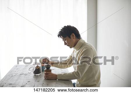 Stock Photography - Japanese man making coffee at home. Fotosearch