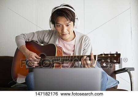 Japanese man playing guitar at home View Large Photo Image Stock Photograph - Japanese man playing guitar at home. Fotosearch