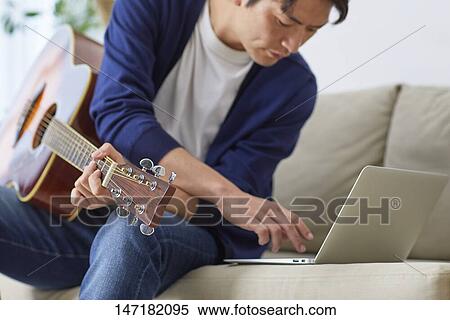 Japanese man playing guitar at home View Large Photo Image Stock Photography - Japanese man playing guitar at home. Fotosearch