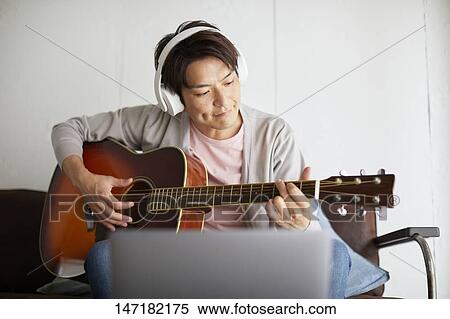 Japanese man playing guitar at home View Large Photo Image Stock Photography - Japanese man playing guitar at home. Fotosearch