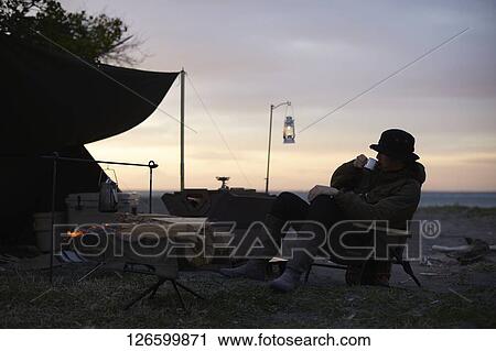 Stock Image - Japanese man solo camping. Fotosearch