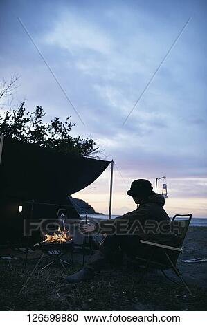 Stock Image - Japanese man solo camping. Fotosearch