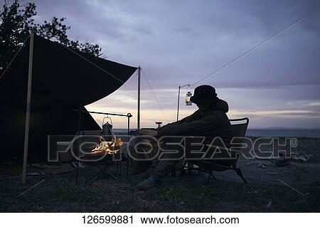 Stock Image - Japanese man solo camping. Fotosearch