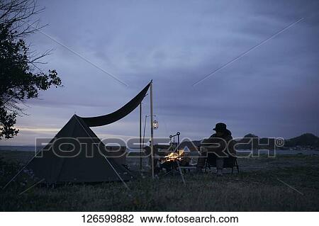 Stock Image - Japanese man solo camping. Fotosearch