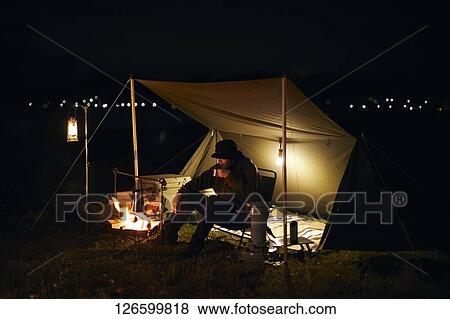 Stock Photo - Japanese man solo camping. Fotosearch