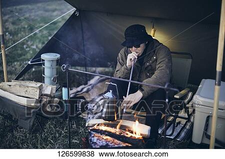 Stock Photo - Japanese man solo camping. Fotosearch